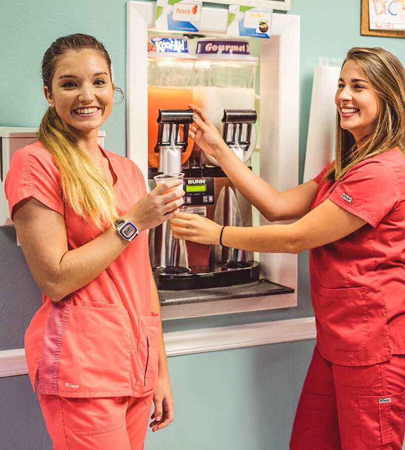 orthodontist-female-assistants-in-pensacola-florida-treat-patients-to-slushy-reducing-discomfort-and-inflamation