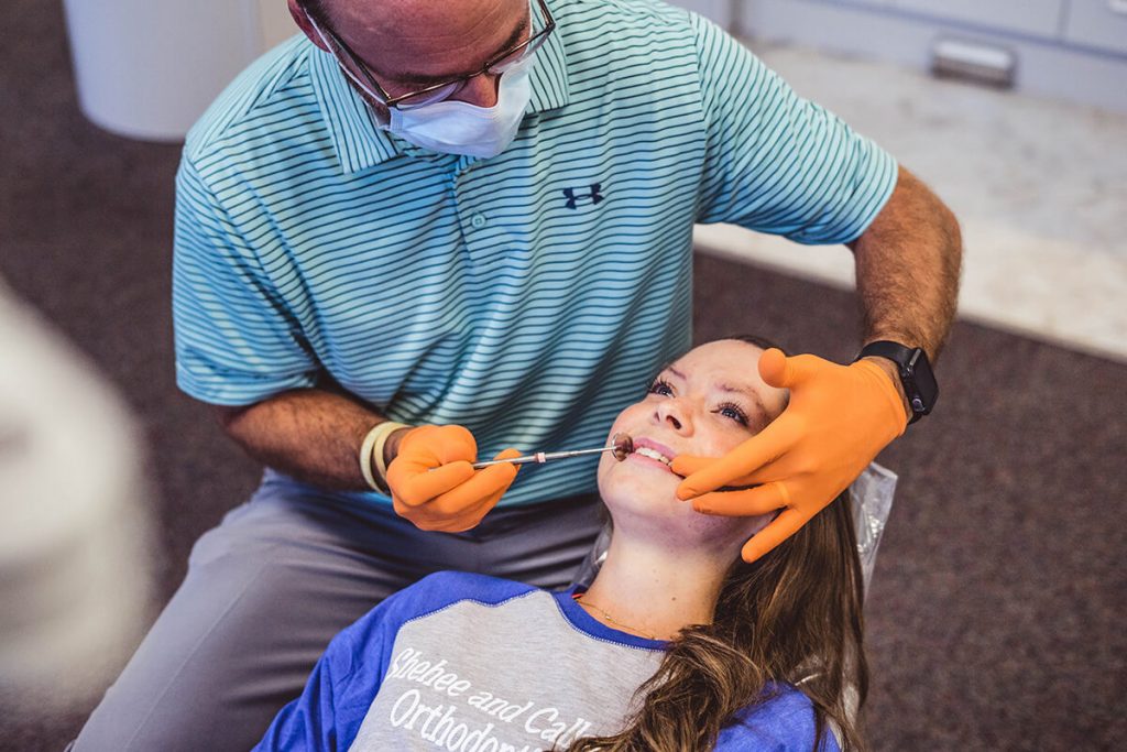 orthodontist-doctor-chad-callahan-performs-braces-exam-on-female-patient-in-milton-florida-office